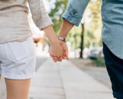 unmarried couple holding hands and walking.